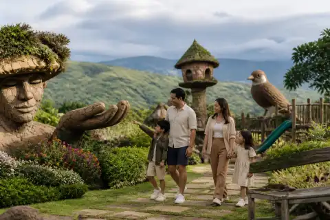 Family strolling past giant themed sculptures at Campuestohan in the Talisay highlands near Bacolod