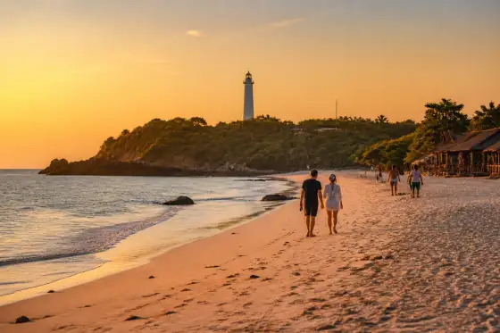 Patar Beach at sunset with pale sand and distant lighthouse