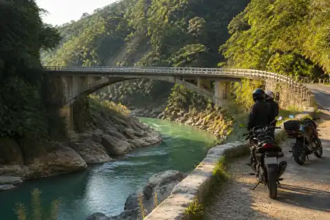 Bitbit Bridge and green river with motorcycles parked at a safe roadside viewpoint