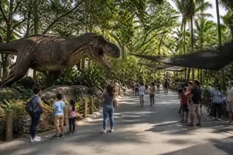 Outdoor dinosaur trail with animatronic and visitors at Dinosaurs Island, Clark