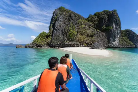 Tour boat near a sandbar and limestone islet in the Gigantes Islands, Iloilo