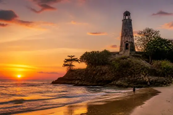Guisi lighthouse ruins and rocky coastline at sunset