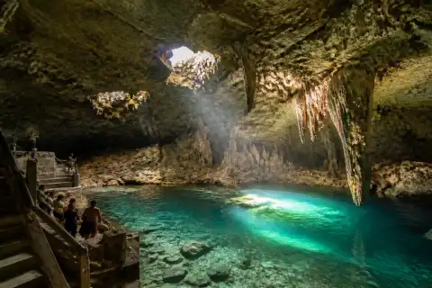 Hinagdanan Cave interior with sunlit underground lagoon and stairs