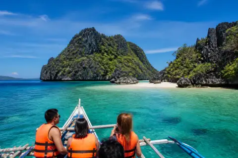 Banca approaching limestone islands and sandbar in Iloilo