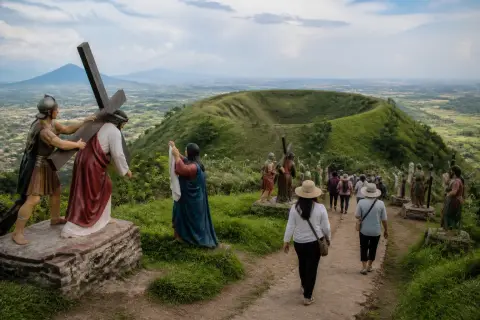Visitors walking past Stations of the Cross sculptures on Kawa-Kawa Hill with Albay landscape in the background