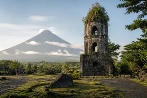 Mayon Volcano rising above the Cagsawa Ruins bell tower and volcanic plain