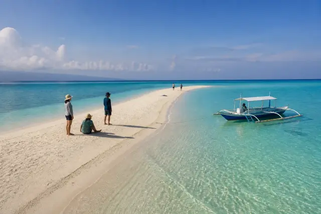 Kalanggaman sandbar with a small outrigger boat and clear turquoise water