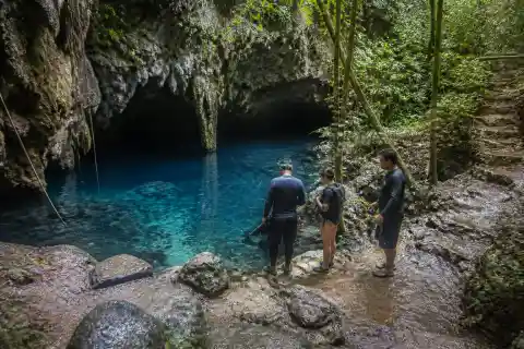Limestone cave entrance and clear blue freshwater pool at Linao Cave
