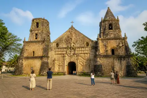 Miagao Church carved façade and twin bell towers viewed from the town plaza