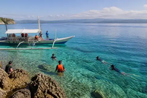 Outrigger banca and snorkelers near Pescador Island off Moalboal