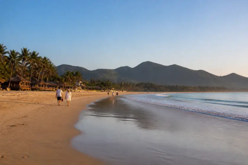 Nacpan Beach long sandy shoreline with gentle waves and palm trees