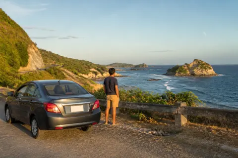 Car at a Pangasinan coastal viewpoint overlooking rocky shoreline and small islands
