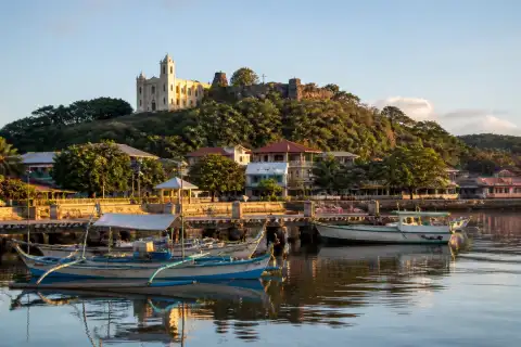 Early morning view of Culion harbor with boats and the church on the hill