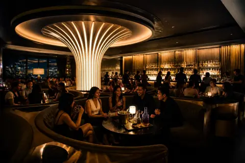 Upscale lounge interior with curved booths and bottle service at Revel, Uptown BGC