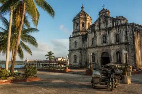 Historic parish church and town plaza in Samar with coastal background
