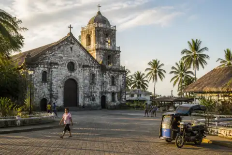 Historic stone church and town plaza in a Samar coastal town at dusk