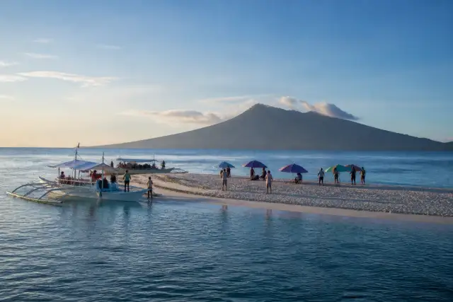 White Island sandbar off Yumbing with small boats and volcano silhouette