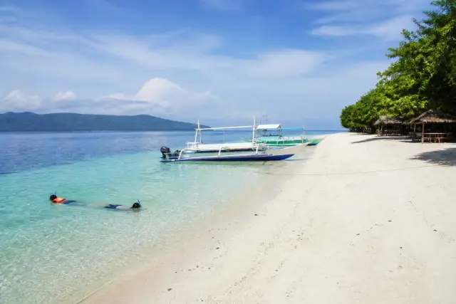 Babu Santa white‑sand beach on Talikud with small boats and clear water