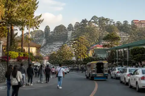 Pedestrians, taxis and a jeepney on a hilly central Baguio street near Burnham Park