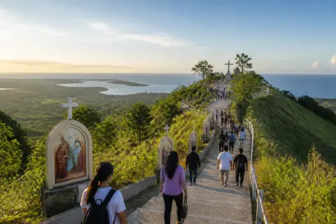 Pilgrims ascending Balaan Bukid with views over the Iloilo Strait