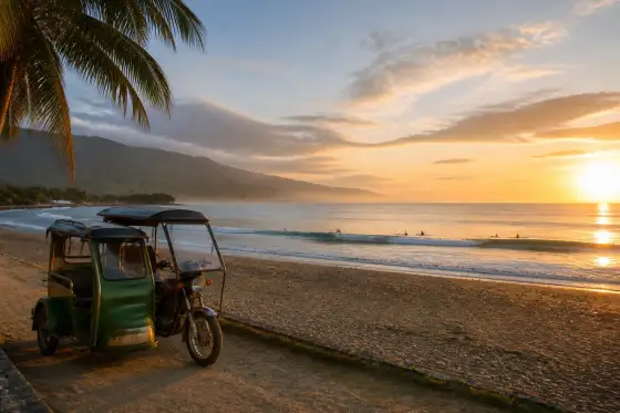 Sunrise at Sabang Beach in Baler with surfers and a parked tricycle