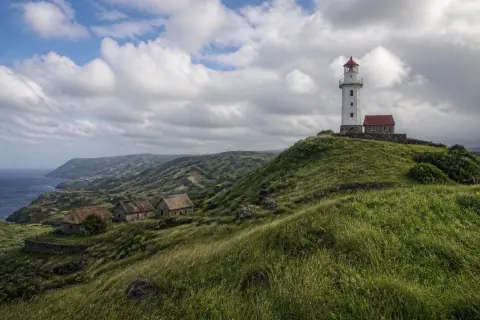Basco Lighthouse on Naidi Hills with rolling grasslands in Batanes