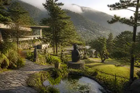 Terraced garden and sculptures at BenCab Museum with mountain backdrop
