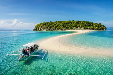 Sumilon Island white sandbar with a banca approaching in clear turquoise water