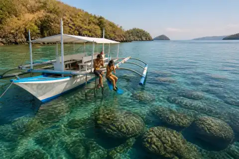 Snorkelers and a small motorboat anchored over shallow reef near Culion