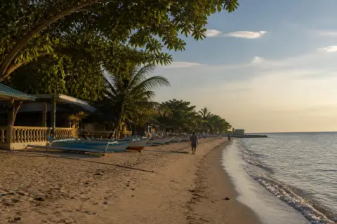 Bolo Beach shoreline with cottages and small fishing boats at late afternoon