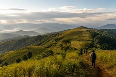 Rolling Bukidnon highlands near Impasug-ong with hikers on a ridge and misty mountains
