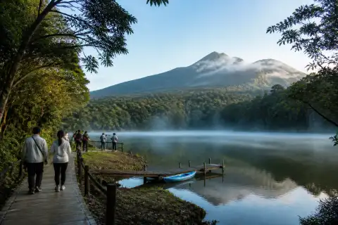 Bulusan Lake with forested shoreline, walkway and misty volcanic slopes