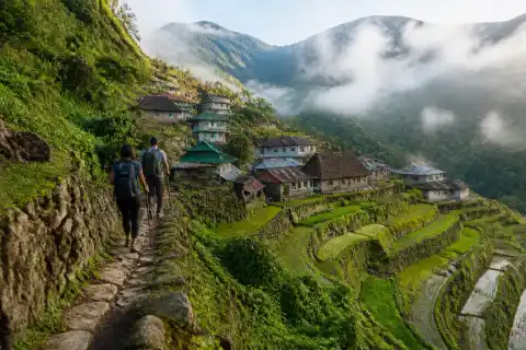 Hikers on a narrow terrace path above Cambulo village rice terraces