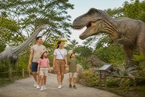 Family walking among dinosaur models at Dinosaurs Island in Clark