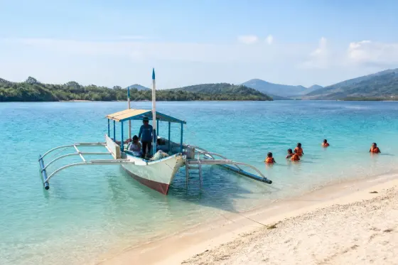 Banca anchored beside a pale sandbar and shallow turquoise sea near Culion