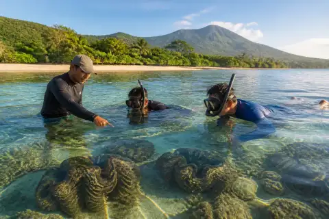 Snorkeler and guide observing giant clams in shallow clear water off Cantaan, Camiguin
