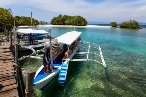Wooden island-hopping boats at Sta. Lourdes Wharf with Honda Bay islands in the distance