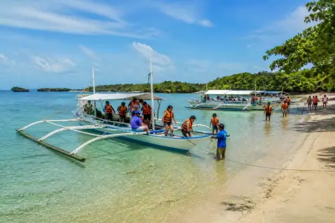 Bancas and visitors at a sandy island in Honda Bay near Puerto Princesa