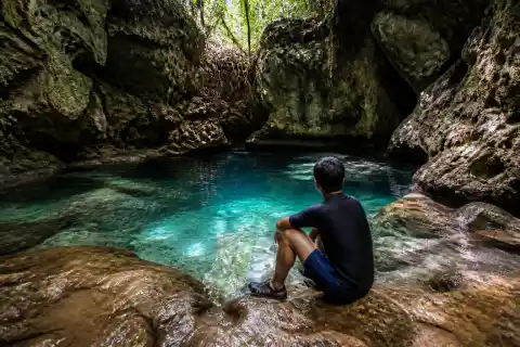 Small limestone cave pool with clear spring water and karst walls in Anda, Bohol