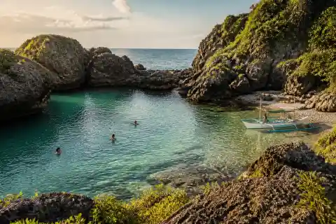 Rocky coastal natural pool at Immuki, Paraoir, La Union with swimmers