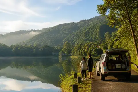 Lakeside road and morning reflections at Lake Sebu with forested hills
