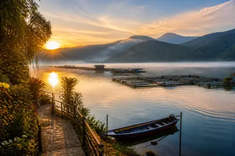 Lake Seloton at sunrise with fish pens and forested hills