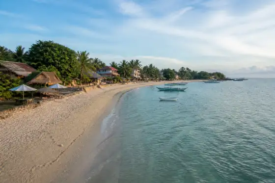 Langub (Langob) Beach north shoreline with pale sand and small boats
