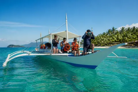 Small banca anchored off Malapascua with passengers preparing to snorkel