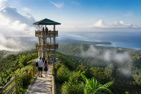 Viewing tower on Mount Bandilaan above forest with island panorama and morning mist