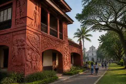 Brick-red Museo de Baler façade with sculpted reliefs beside Quezon Park trees