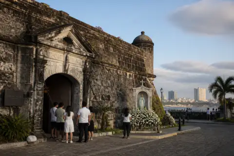 Fort Pilar stone walls, museum entrance and Marian shrine with visitors