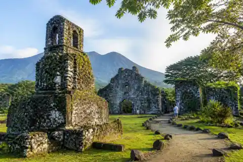 Moss-covered coral-stone walls and bell-tower base of Old Bonbon church ruins, Camiguin