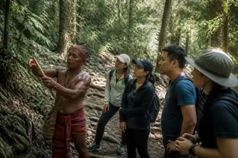 Aeta guide leading visitors along a shaded tropical trail in Pamulaklakin Forest, Subic