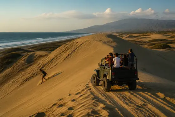 4×4 vehicle and sandboarder on Paoay coastal sand dunes at late afternoon